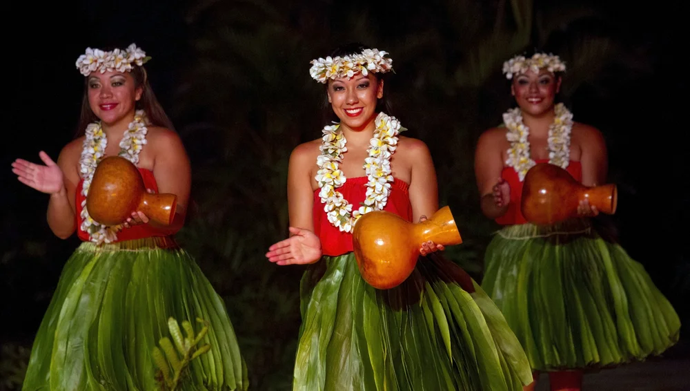Attractive young women in traditional dress perform Hawaiian